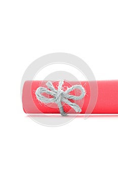 Handmade natural rope node tied on red paper scroll isolated