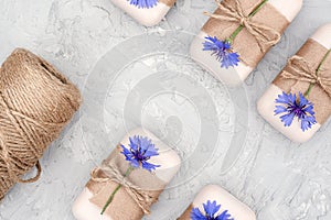 Handmade natural soap set decorated with craft paper, scourge and blue flowers. Organic cosmetics concept. Top view Flat lay Copy