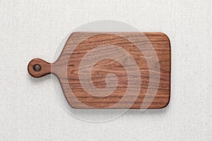 Handmade North American black walnut wooden chopping board on sackcloth. Walnut wood chopping board texture.