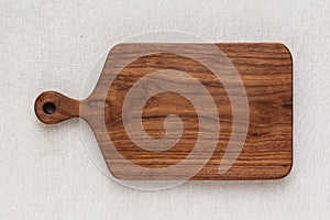 Handmade North American black walnut wooden chopping board on sackcloth. Walnut wood chopping board texture. photo