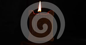 Handmade oil lamp with Om symbol used in Deepavali, Maha Shivaratri and many other religious festivals glows on a dark background