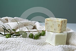 Handmade olive soap with olive branch and a towel.