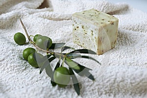 Handmade olive soap with olive branch and a towel.