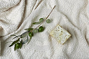 Handmade olive soap with olive branch and a towel.