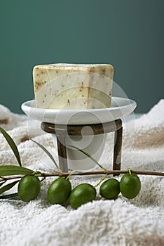 Handmade olive soap with olive branch and a towel.