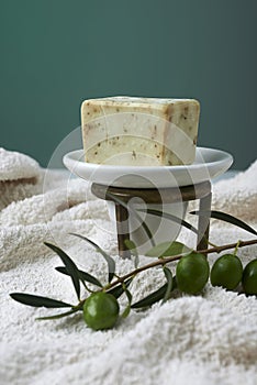 Handmade olive soap with olive branch and a towel.