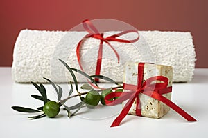 Handmade olive soap with olive branch and a towel, as a gift.