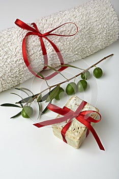 Handmade olive soap with olive branch and a towel, as a gift.