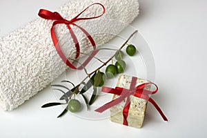 Handmade olive soap with olive branch and a towel, as a gift.