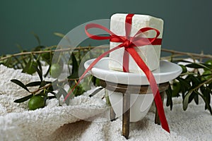 Handmade olive soap with olive branch and a towel, as a gift.