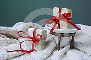 Handmade olive soap with olive branch and a towel, as a gift.