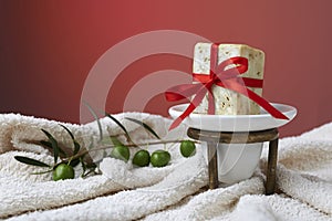 Handmade olive soap with olive branch and a towel, as a gift.