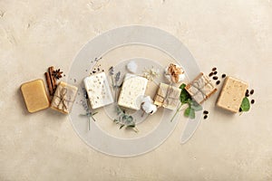 Handmade organic soap bars and ingredients on natural stone background, flat lay