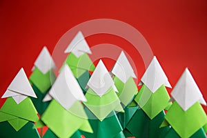 Handmade origami paper craft Christmas tree on red background