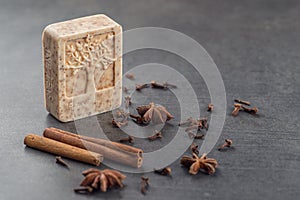 Handmade ornamental soap with cinnamons and anise on black background, product of cosmetics and body care
