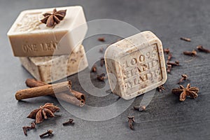 Handmade ornamental soaps with cinnamons and anise on black background, product of cosmetics and body care