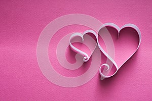 Handmade paper heart shapes decoration on pink background