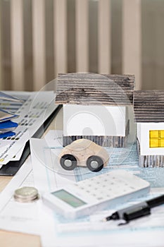 Handmade paper houses on the table. Papers,pen,calculator,coins