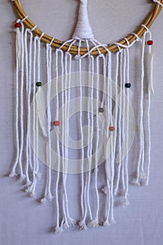 Handmade pink dream catcher with white doily on background of ro
