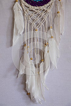 Handmade pink dream catcher with white doily on background of ro