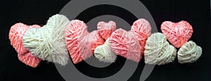 Handmade pink and white wool yarn heart on black banner