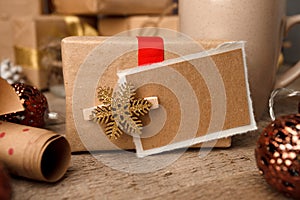 Handmade present box with tags on vintage wooden background, christmas decor closeup, copy space.