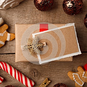 Handmade present box with tags on vintage wooden background, christmas decor closeup, copy space.