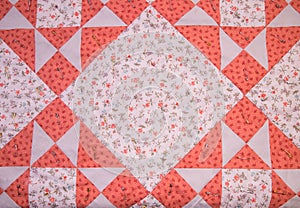 A handmade quilt pattern of squares and triangles sewn with batting pinned