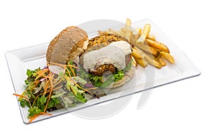 Handmade Quinoa Tofu Patty burger with fries and salad served in dish isolated on plain white background side view of fastfood