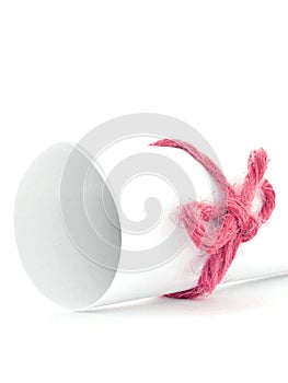 Handmade red cord node tied on white paper scroll isolated