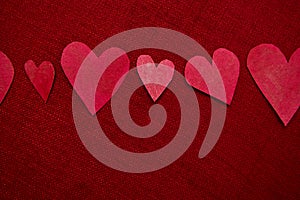Handmade red hearts on red background