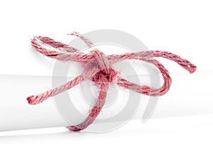 Handmade red string knot tied on white paper roll isolated
