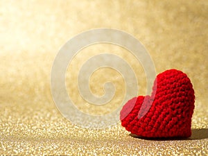 Handmade red yarn heart on gold abstract background. Copy space for text, Valentines day, love concept and love background