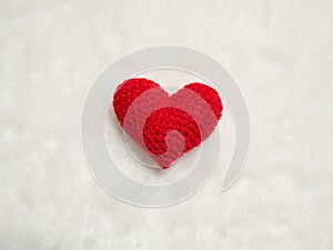 Handmade red yarn heart on white wool. the red heart on the center of picture and background copy space for text. Valentines day,