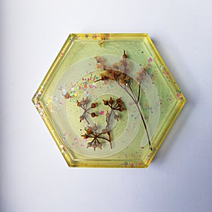 Handmade resin coaster with floral pattern on white background