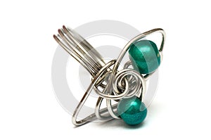 A handmade ring with silver metal and emerald green beads white backdrop