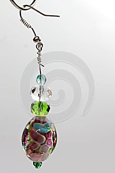 Handmade robust earring with multicolored glass gem as main element