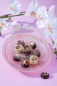 Handmade rustic chocolate truffles with white orchid flowers on pink