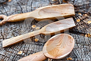 Handmade rustic wooden spoons on a stump