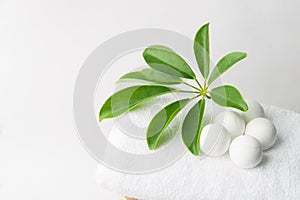Handmade salt bath bombs in balls shape from organic vegan natural ingredients on white towel green house plants. Spa wellness