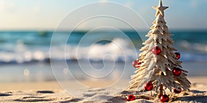 Handmade Sandy Christmas Tree with Star Topper and Red Ornaments on Tropical Beach with Ocean Background during Daytime