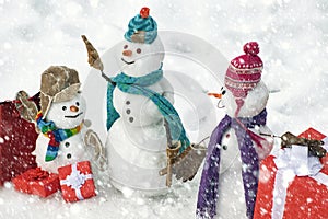 Handmade snowman in the snow outdoor. Greeting snowman. Winter snowman family. Mother snow-woman, father snow-man and