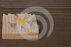 Handmade soap bar with plumeria on timber