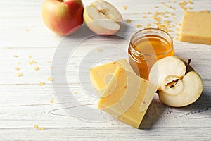 Handmade soap bars, apple and jar of honey on table