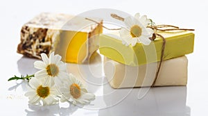 Handmade soap bars and chamomile on white background