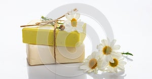 Handmade soap bars and chamomile on white background