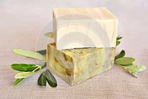 Handmade soap bars and olive branches on gunny background
