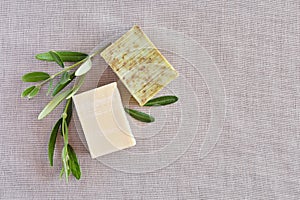Handmade soap bars and olive branches on gunny background.