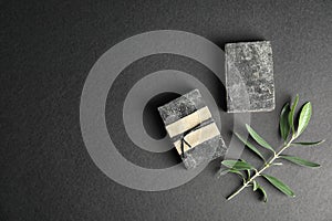 Handmade soap bars with olive twig and space for text on black background