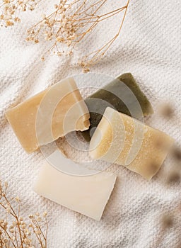 Handmade soap bars on white towel top view